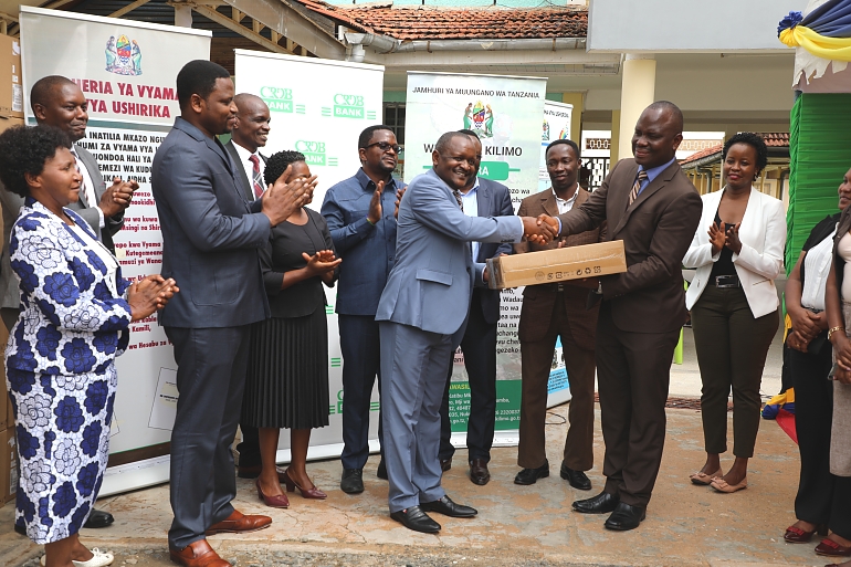Katibu Mkuu Wizara ya Kilimo, Bw. Gerald Kusaya akimkabidhi Kompyuta Mrajis na Mtendaji Mkuu wa Tume ya Maendeleo ya Ushirika, Dkt. Benson Ndiege